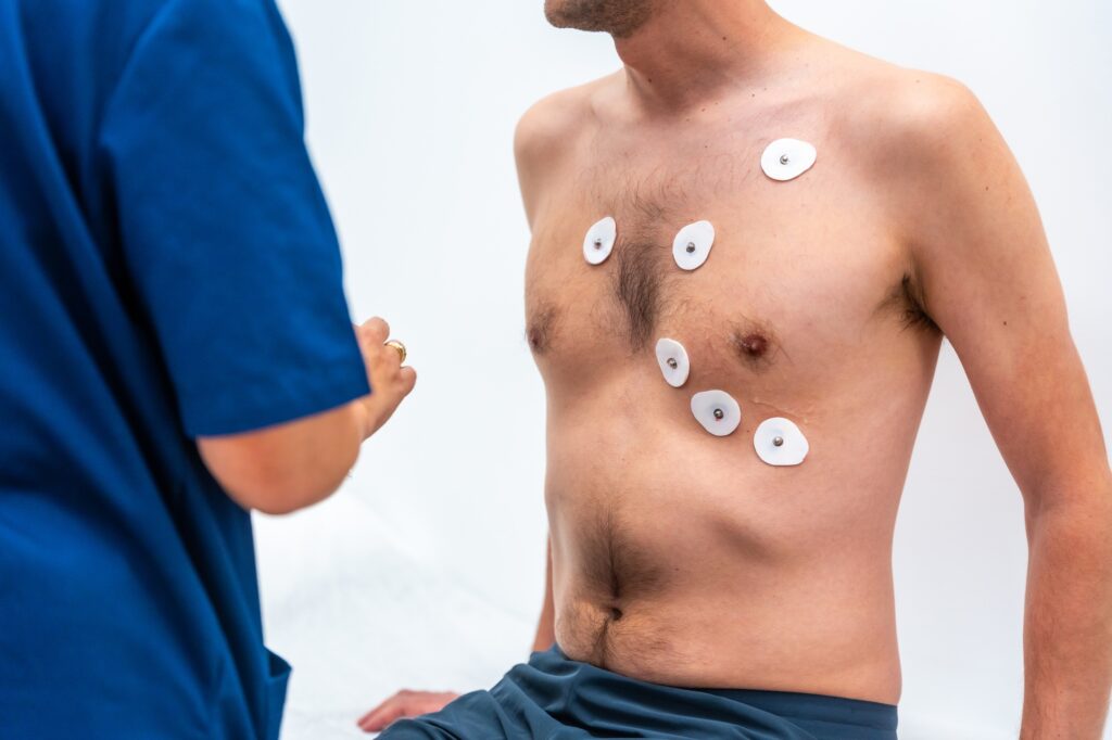 Cardiologist placing electrodes to perform an echocardiogram to a patient