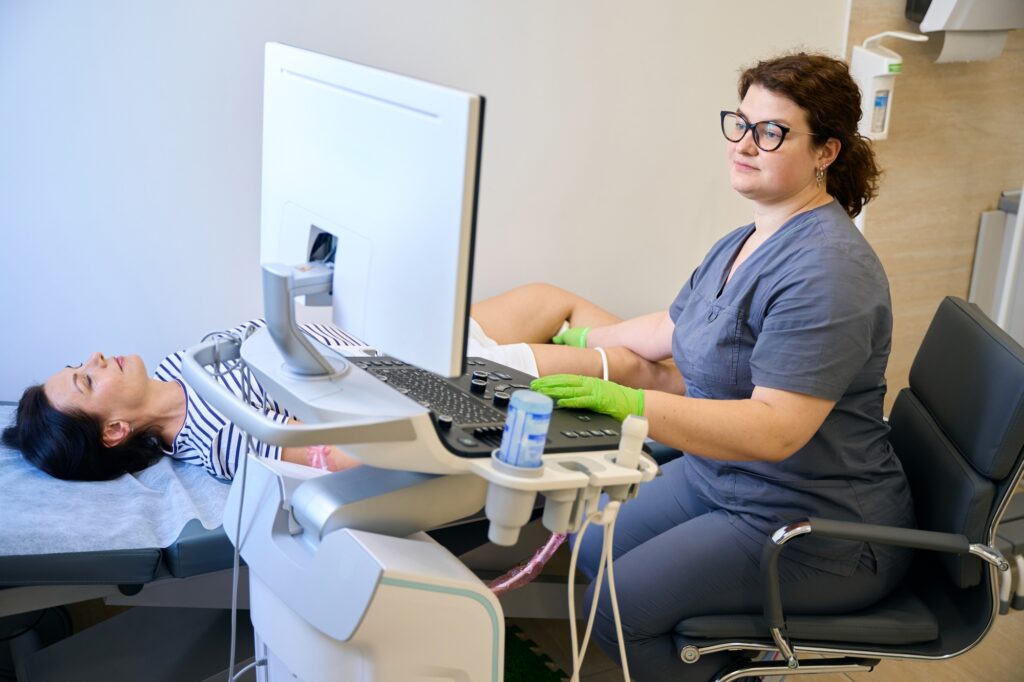 Clinic employee at her workplace performs an ultrasound diagnosis