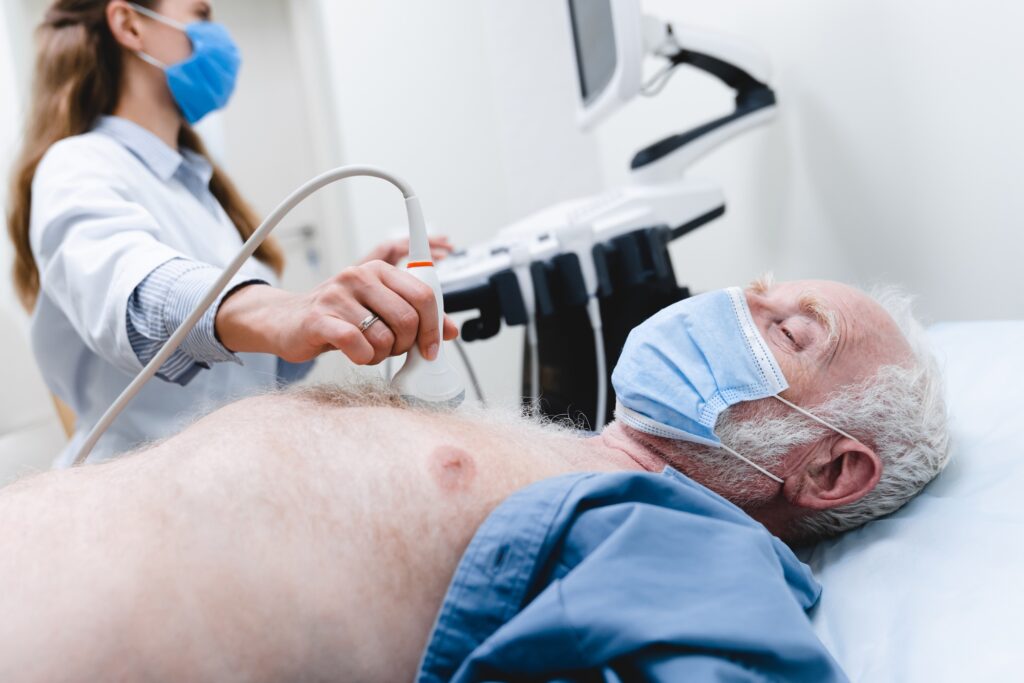 Close up photo of an elderly patient wearing mask undergoing ultrasound chest